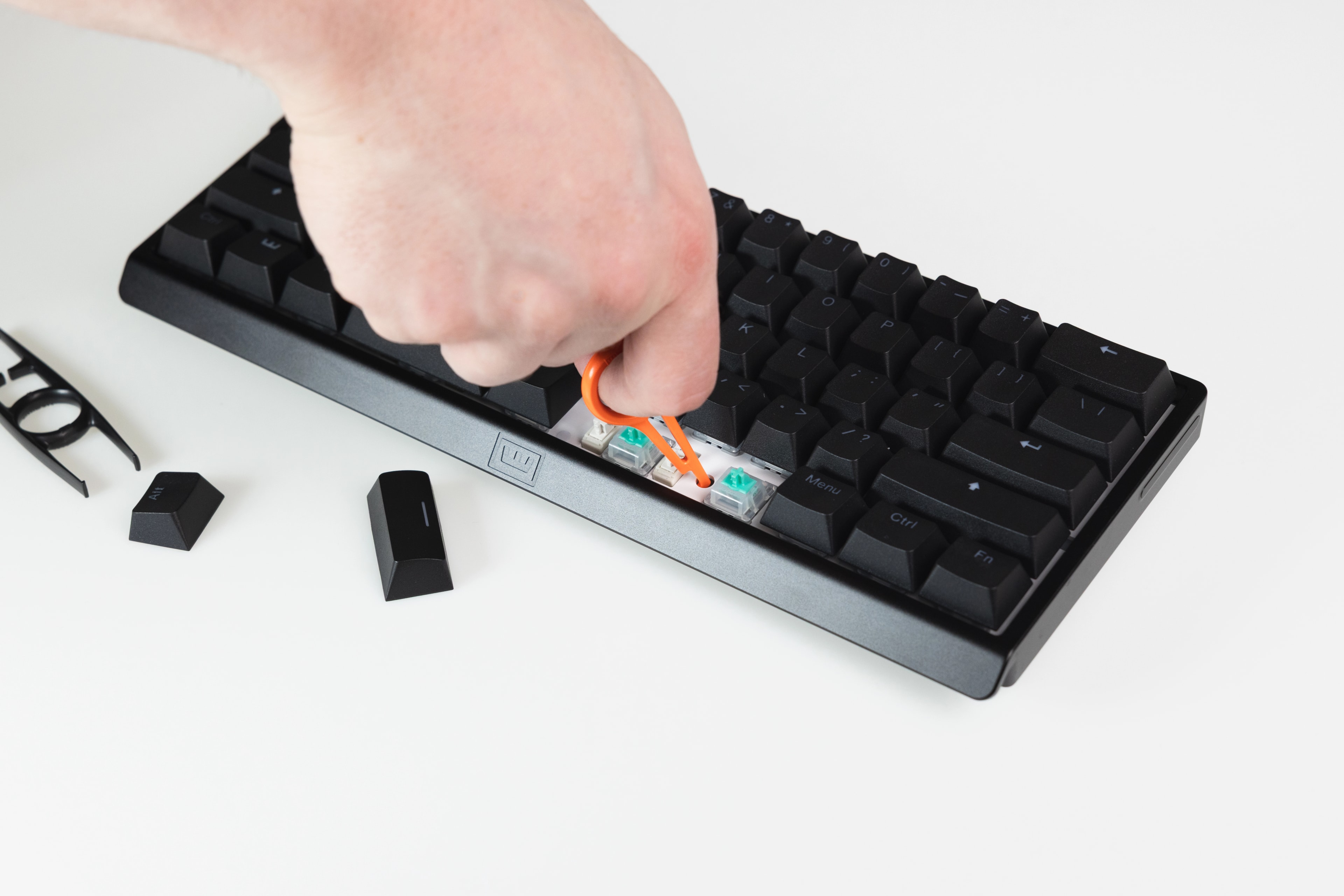 Wooting 60HE v2 showing the alignment of the PCBA puller tool over the exposed hole